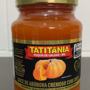 Frasco de doce cremosa de abóbora com coco, da marca Tatitânia, com rótulo colorido e detalhes sobre ingredientes e fabricação.